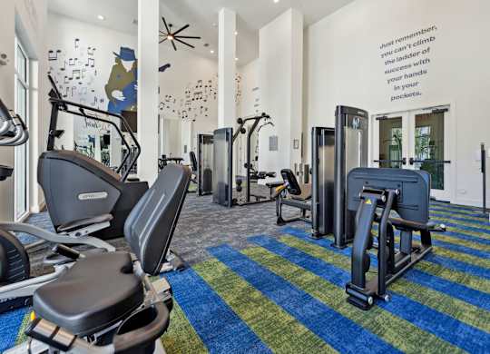 a gym with treadmills and other exercise equipment in the lobby of a building