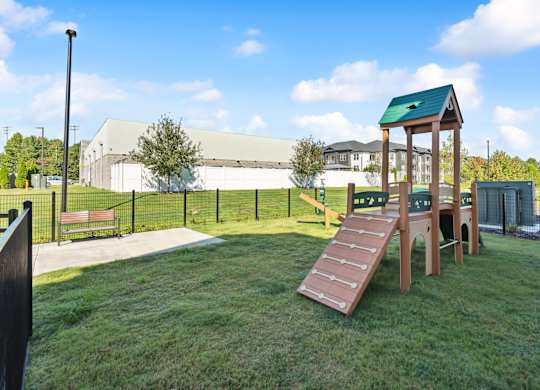a playground in a park with a wooden playset