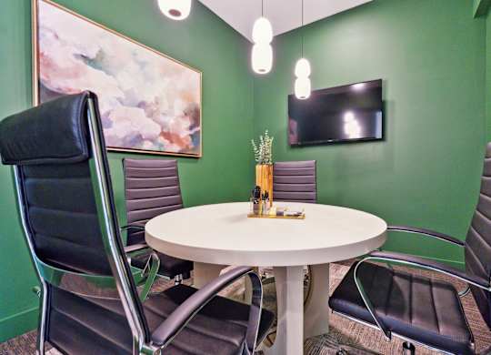 a meeting room with a table and chairs and a television
