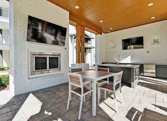 a patio with a table and chairs and a fireplace