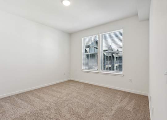 an empty room with carpet and a window