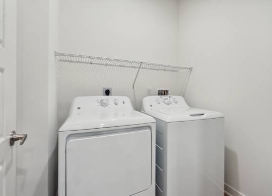 a white washer and dryer in a white laundry room