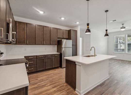 an open kitchen with a white counter top and wooden cabinets