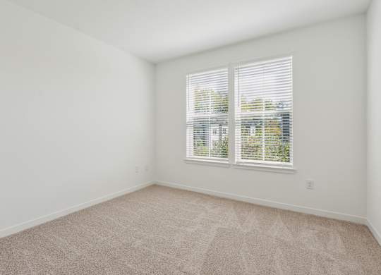 an empty room with white walls and a window