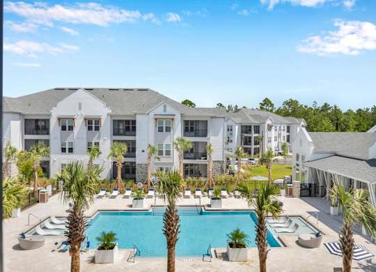 A large white building with a pool in front.