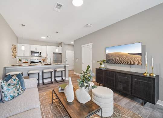 A modern living room with a grey couch, a coffee table, and a large painting on the wall.