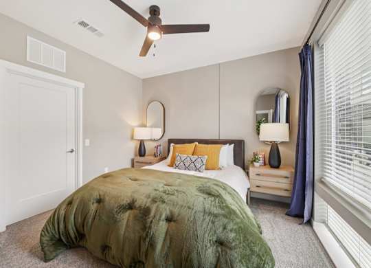 A bedroom with a bed, nightstand, and window.
