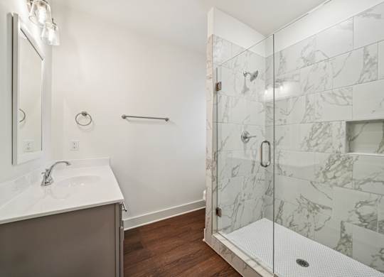 Luxury bathroom with glass door shower and marble tile at Turnberry Park Apartments