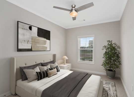 a bedroom with a large bed and a ceiling fan at The Cottages at Foley Farms apartments in Foley, AL