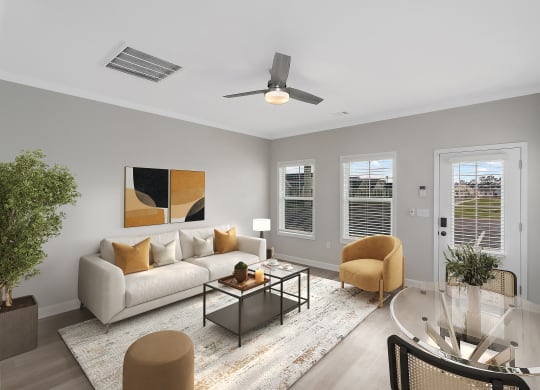 a living room with a couch and a coffee table and a ceiling fan at The Cottages at Foley Farms apartments in Foley, AL