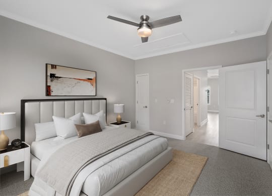 a bedroom with a large bed and a ceiling fan at The Cottages at Foley Farms apartments in Foley, AL