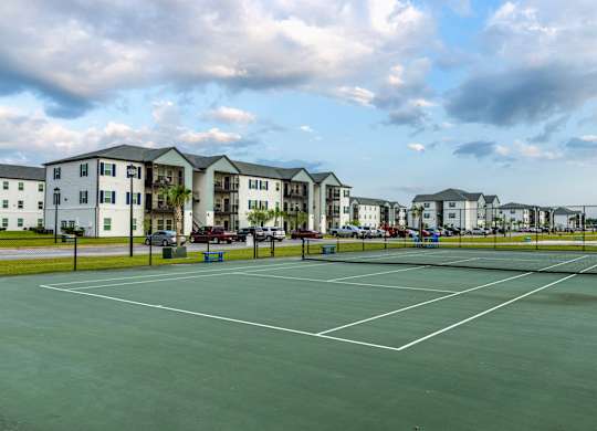 a tennis court at the whispering winds apartments in pearland, tx