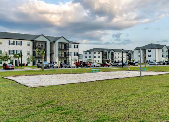 a grassy area with several apartment buildings in the background