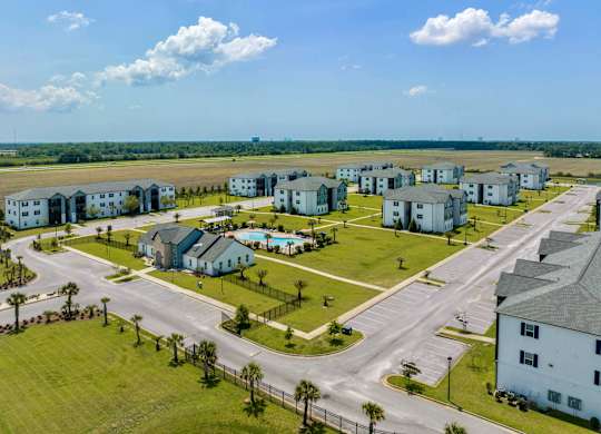an aerial view of a housing complex with a runway in the background