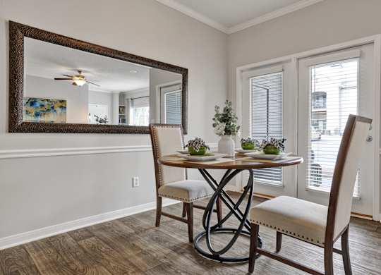 Dining room with plank flooring and fireplace at Village at Caldwell Mill in Birmingham, AL
