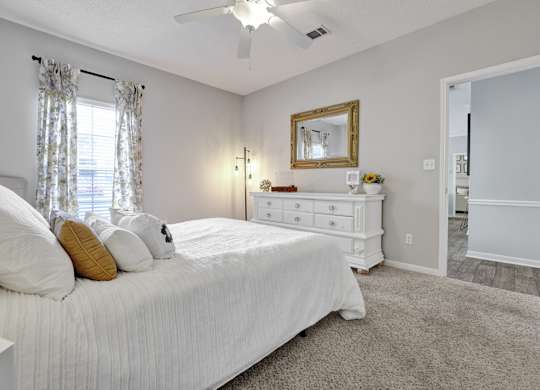 Bedroom with plush carpet and window at Village at Caldwell Mill Apartments in Birmingham, AL