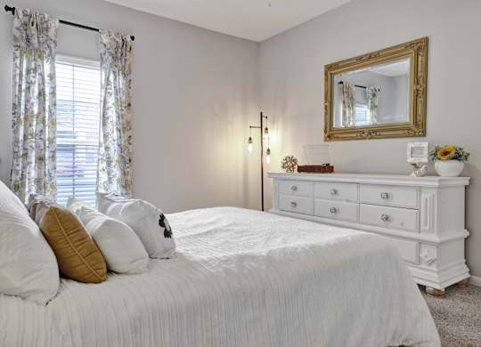 Bedroom with plush carpet and window at Village at Caldwell Mill Apartments in Birmingham, AL