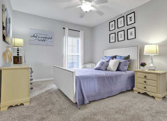 Bedroom with plush carpet and window at Village at Caldwell Mill Apartments in Birmingham, AL
