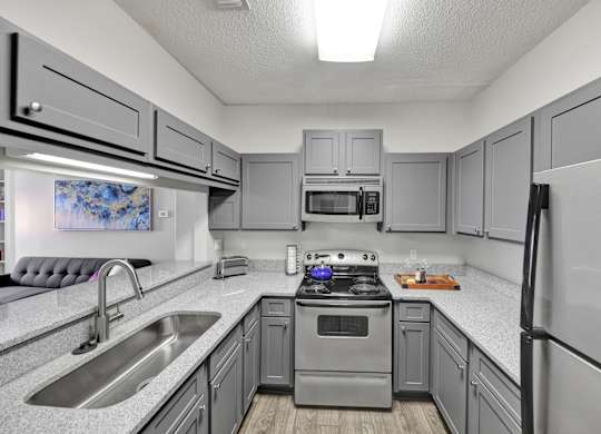A remodeled kitchen with stainless steel appliances at Village at Caldwell Apartments in Birmingham, AL