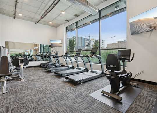 A gym with treadmills, elliptical machines, and other exercise equipment.