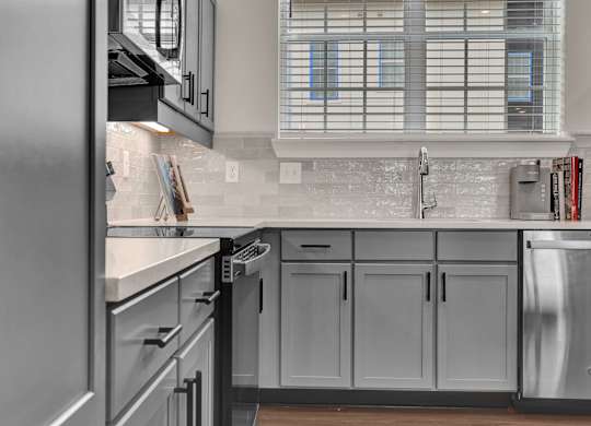 A modern kitchen with stainless steel appliances and a subway tile backsplash at West Row Lofts and Townhomes in Birmingham, AL