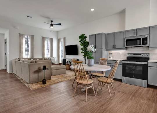 A modern kitchen and living room with wood-designed flooring at West Row Townhomes and at West Row Townhomes at West Row Lofts and Townhomes in Birmingham, AL