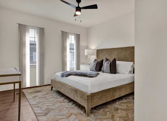 A bedroom with a large bed and a ceiling fan at West Row Townhomes and at West Row Townhomes at West Row Lofts and Townhomes in Birmingham, AL