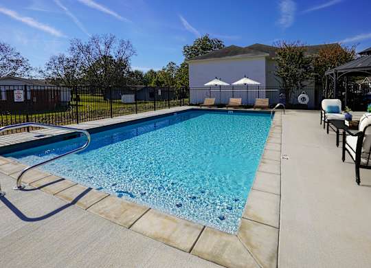 A swimming pool with a slide and a chair.