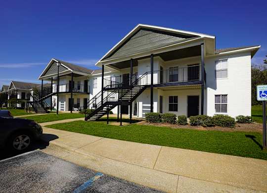 A white building with a black staircase in front.