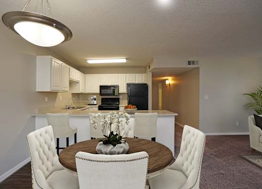 A modern kitchen with a dining table and chairs.