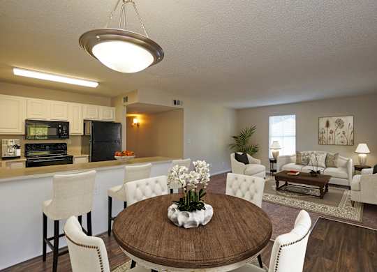 A modern dining room with a wooden table and white chairs.
