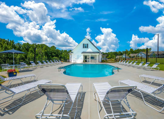the swimming pool at the retreat at thousand oaks apartments with white chairs around it