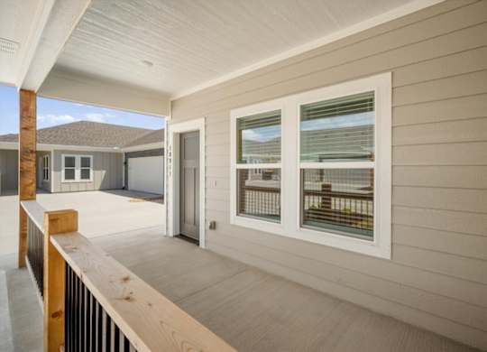 A balcony with a sliding door and a window overlooking a beach.