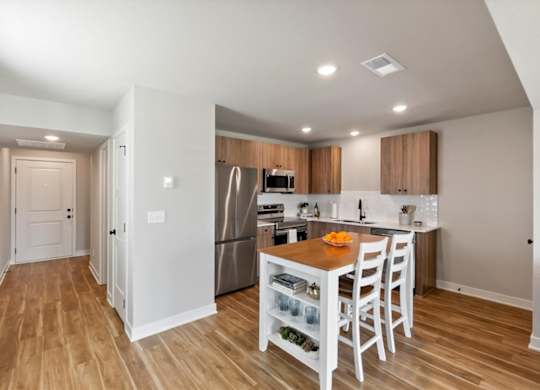 A kitchen with a table and chairs in the middle of the room.