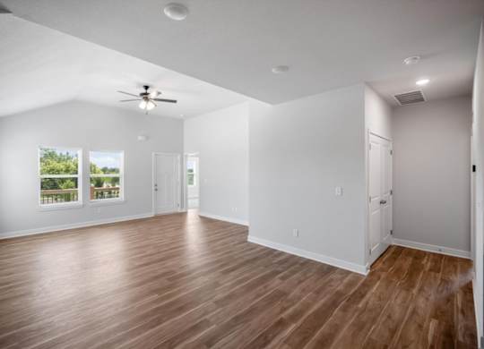 A room with wooden floors and a ceiling fan.