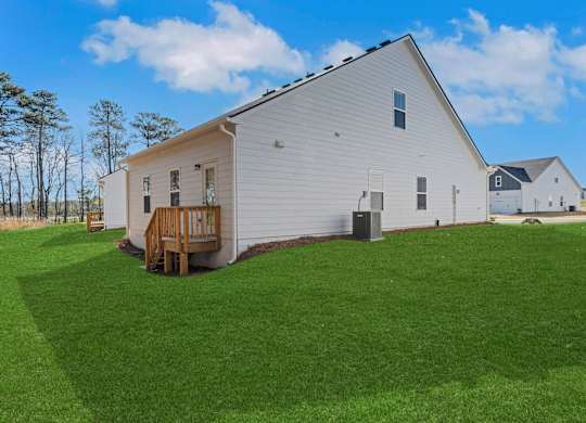 A white barn with a wooden deck in the front.