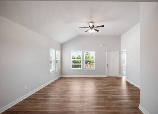 A room with a ceiling fan and wooden flooring.