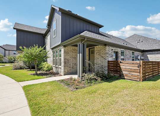 A house with a grey roof and a wooden fence.