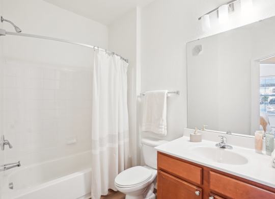 A white bathroom with a toilet, sink, and bathtub.