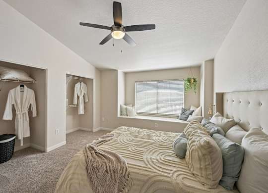 A bedroom with a large bed and a ceiling fan.