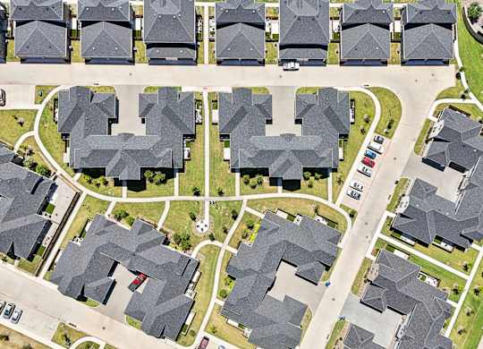 A bird's eye view of a neighborhood with houses and streets.