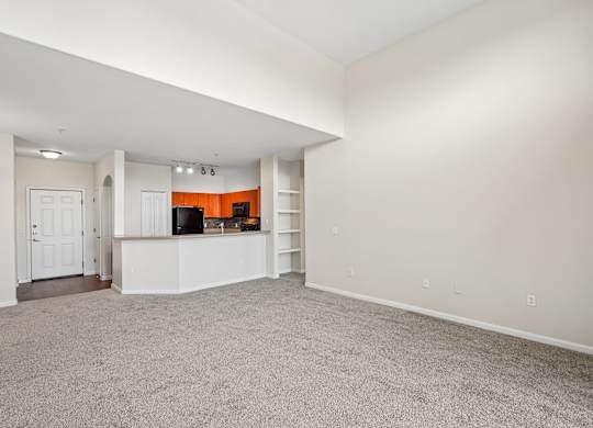 A spacious living room with a television and built-in shelves.