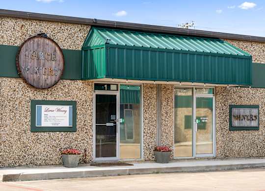 The front of a building with a green awning and a sign that reads Large Pilsners.