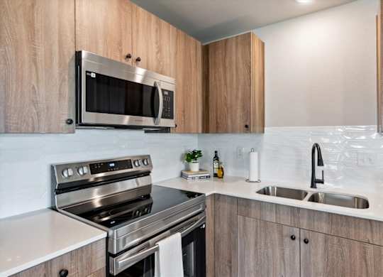 A modern kitchen with wooden cabinets and stainless steel appliances.