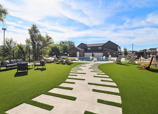 A large outdoor area with a grassy lawn and a pathway with steps at Townhomes at Princeton Meadows