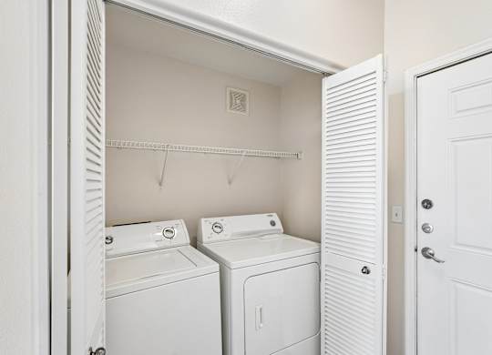 A white laundry room with a washer and dryer.