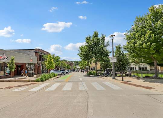 A street view with a crosswalk and a sign on the right.