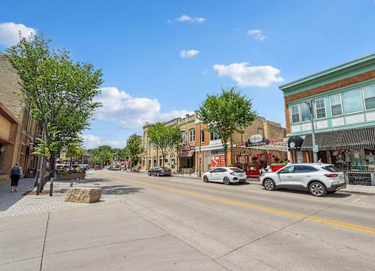 A street view of a town with cars parked on the side of the road.