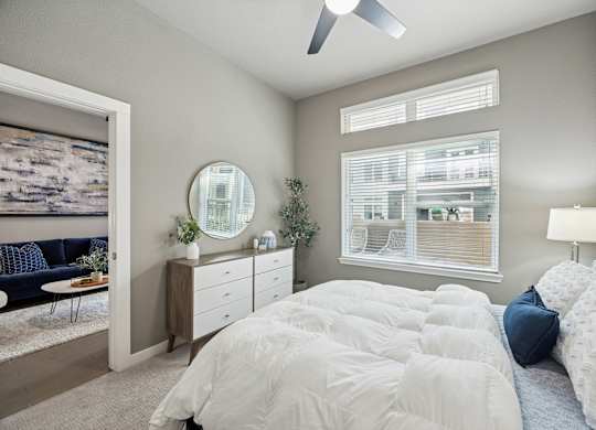 A bedroom with a large bed and a ceiling fan.