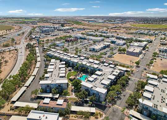 A bird's eye view of a residential area with a road curving around it.